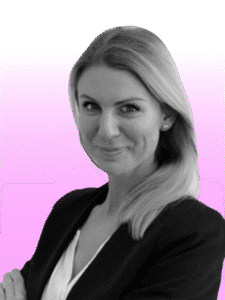 A woman with long, straight hair and a slight smile, dressed in a blazer over a top, stands in front of a pink and white gradient background—perfect for showcasing professionals at corporate events in Spain.